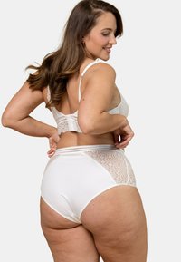 Ensemble de soutien-gorge en dentelle blanche avec bordure en dentelle et culottes taille haute, featuring des panneaux en dentelle transparente et un tissu doux. Design classique avec des bretelles réglables.