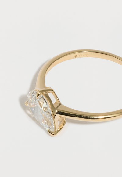 Χρυσό δαχτυλίδι με μεγάλο οβάλ διαμάντι σε διάφανη απόχρωση, στερεωμένο με τέσσερα νύχια σε απλό, γυαλισμένο δαχτυλίδι.