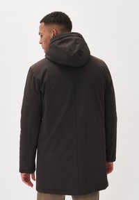 Dark, hooded parka with a smooth, matte finish. Features side button closures and a mid-length cut, designed for warmth and coverage.