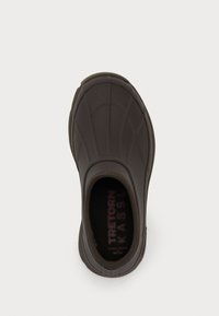 Pantof brown cu slip-on, cu o suprafață texturată asemănătoare cauciucului, vârf rotunjit și un interior cu branding imprimer pe talpa interioară.