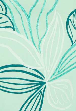 Abstracte bladerenpatronen in teal en wit met turkoois glitteraccenten op een lichtgroene stoffen achtergrond.