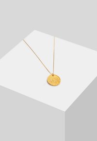 Kuldpendant kaelakee tekstuuriga ringsest ripatsist, õhukese kullast kettiga, minimaalses heledas taustas.