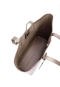 Hnědá kožená taška přes rameno s otevřeným designem, nabízející hladký povrch a razítkovaný interiér se textem "VYJDI Z OLYRY".