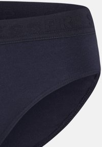 Slip in cotone blu navy con un elastico abbinato in vita caratterizzato da logo in rilievo. Texture liscia e forma standard dell'intimo.