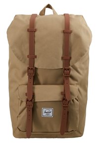 Brązowy plecak z płótna z brązowymi skórzanymi paskami, przednią kieszenią i naszywką z logo. Ustrukturyzowany kształt z klapą zamykającą i regulowanymi paskami.
