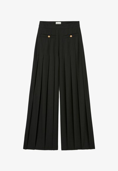 Pantalons larges noirs avec un design plissé, comprenant deux poches avant et des boutons dorés sur les rabats des poches. Texture de tissu lisse.