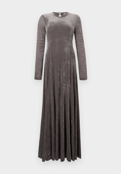 Robe maxi en velours gris à manches longues avec un décolleté rond, jupe évasée et un éclat subtil. Ouverture en forme de trou de serrure dans le dos pour le détail de fermeture.