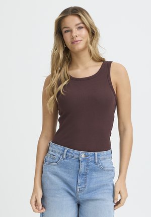 Débardeur côtelé bordeaux avec un col rond, associé à un jean taille haute bleu clair. Texture lisse avec une coupe ajustée.