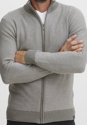 Grå zip-up tröja med ribbad krage och manschetter. Har horisontella ränder och en slim fit-design. Texturerad stickad tyg.