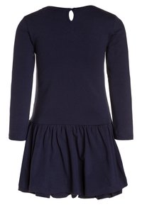 Námořnická modrá dlouhá šaty s kulatým výstřihem, nařasenou sukní a detailem v podobě klíčové dírky na zádech. Vyrobeno z měkké, elastické tkaniny.