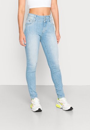 Lichtblauwe skinny jeans van denim, met een hoge taille en dubbele knoopsluiting en een slank model. Draag ze met witte sneakers.