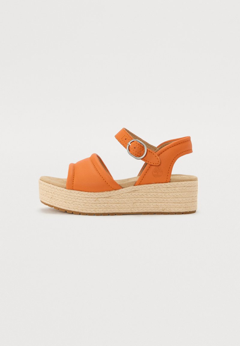 Oransje skinnplatåsandaler med en vevd jute-plattform. Har en bred rem og justerbar stropp med sølvfarge hardware.