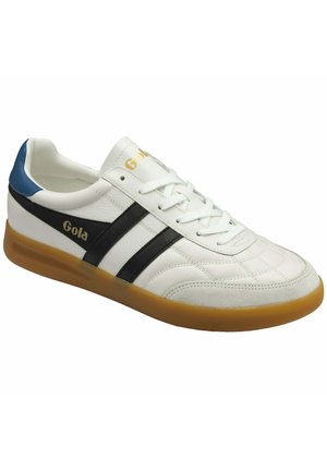Witte leren sneaker met zwarte strepen, blauw hielstuk, gumkleurige zool, witte veters en gouden "Gola" logo aan de zijkant en op de tong.