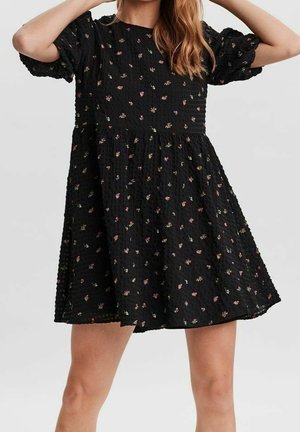 Robe noire avec des manches bouffantes, en tissu texturé, broderie florale éparpillée en rose et jaune, longueur genou, coupe décontractée, col rond.