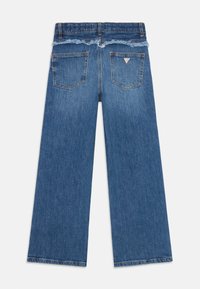 Jeans de denim de perna larga com uma cintura e bainha desfiadas, na cor azul clara, com dois bolsos traseiros e um pequeno detalhe de logotipo.