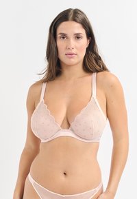 Helle rosa BH mit Spitzenkanten, transparentem Material und gestickten Punktmustern. Verstellbare Satinschulterträger und ein glatter Unterbande.