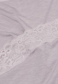 Weicher Lavendelstoff mit einem horizontalen Streifen aus zarter, hellrosa floraler Spitzenborte.