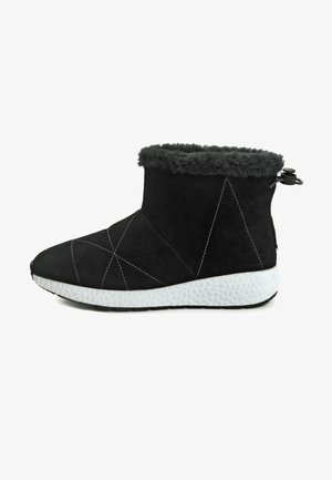 Musta mokkanahkainen nilkkuri, jossa on pörröinen harmaa turkiskaulus, valkoinen teksturoidu pohja ja koristeellinen valkoinen ommeltu. Pyöreä kärki ja takana vetoketju.