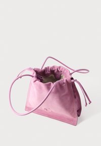 Μαλακή τσάντα χειρός από σουέντ σε απαλό ροζ χρώμα με λεπτό ιμάντα ώμου, ελαφρώς ανοιχτή που αποκαλύπτει την μπεζ εσωτερική επένδυση, πάνω σε λευκό φόντο.