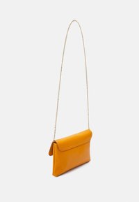 Bolso de mano amarillo de cuero con una cadena, con cierre de solapa y una textura suave. Forma rectangular con líneas limpias.