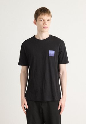 Zwarte T-shirt met korte mouwen van katoen, met een kleine paarse zak met het "HUGO" logo. Eenvoudig ontwerp, ontspannen pasvorm, gladde textuur.