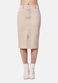 Jupe crayon beige à hauteur des genoux, confectionnée en tissu lisse avec une fente devant, des poches zippées décoratives et des détails de taille cintrée.