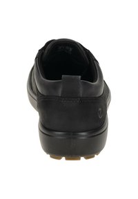 Scarpa sportiva nera con tomaia in pelle liscia, colletto imbottito e suola in gomma testurizzata con un motivo di trazione ben definito.