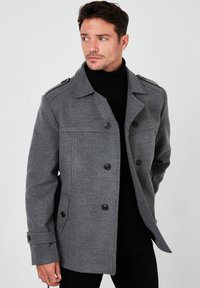 Cappotto in misto lana grigio con chiusura a bottoni, spalline e tasche laterali. Tessuto testurizzato e vestibilità comoda.