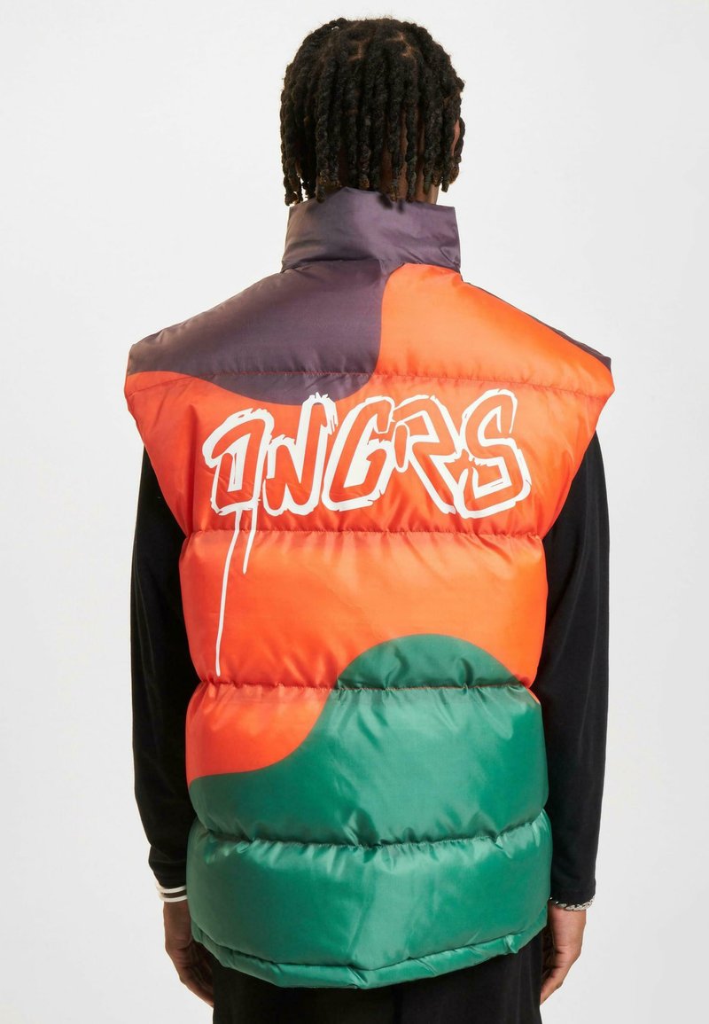 Farverig puffer vest med sektioner i orange, grøn og lilla. Bemærkelsesværdig hvid graffiti-tekst og quiltet tekstur med en høj krave.