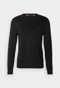 Pull noir à manches longues avec col rond, petit logo rouge, blanc et bleu sur la poitrine gauche, poignets et ourlet côtelés.