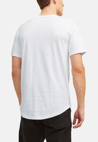 Witte katoenen t-shirt met een klassieke ronde hals. Korte mouwen, relaxte pasvorm en een soepele textuur. Minimalistisch ontwerp, geen zichtbare logo's of patronen.