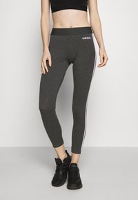 Szare legginsy sportowe o dopasowanym kroju, wysokim pasie i białych paskach po bokach. Wykonane z elastycznego materiału dla wygody.