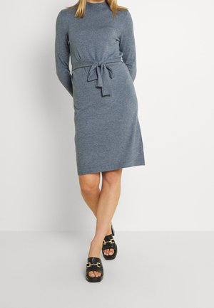 Robe en tricot grise à manches longues, col montant et détail de taille nouée. Présente une silhouette simple et droite avec une texture douce.