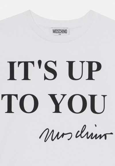Camiseta de algodón blanca con un texto negro en negrita que dice "DEPENDE DE TI" y una firma a mano debajo.