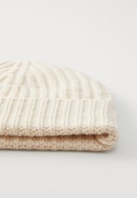 Strickmütze in einer weichen, hellbeigen Farbe, mit einem gerippten Muster und einem umgeschlagenen Bund für zusätzliche Wärme und Stil.