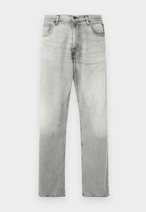 Sive traperice ravnog kroja s izblijedelim pranjem. Uključuju klasični stil s pet džepova i zatvaranje na gumb.