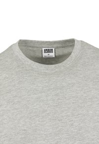 T-shirt gris à col rond fabriqué en coton doux, comportant une étiquette "URBAN CLASSICS" à l'intérieur du col. Design simple avec une texture lisse.
