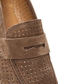 Chaussure à enfiler en daim marron avec un design perforé, un bout arrondi et une bande d'accent texturée sur le dessus. Doublure intérieure lisse.