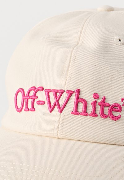 Casquette de baseball couleur crème avec le texte "Off-White" brodé en rose sur le panneau avant, mettant en avant la texture du tissu et les détails de la couture.