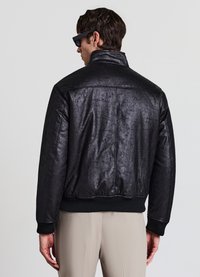 Schwarze Bomberjacke aus Kunstleder mit strukturierter Oberfläche, gerippten Bündchen und Saum. Verfügt über einen hohen Kragen und ein glattes Design.