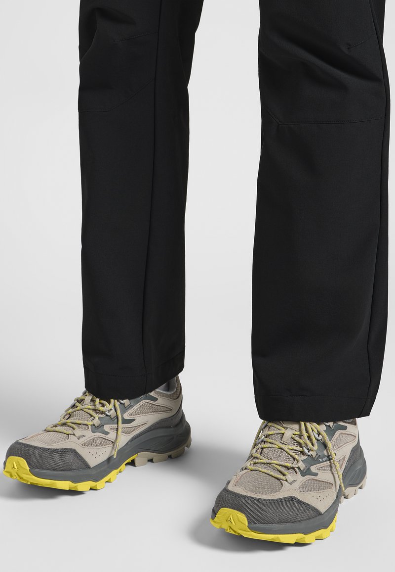 Leichte Wanderschuhe mit einem grauen und beigen Mesh-Obermaterial, gelben Akzenten und einer robusten Außensohle für Grip. Passen gut zu schwarzen Hosen.