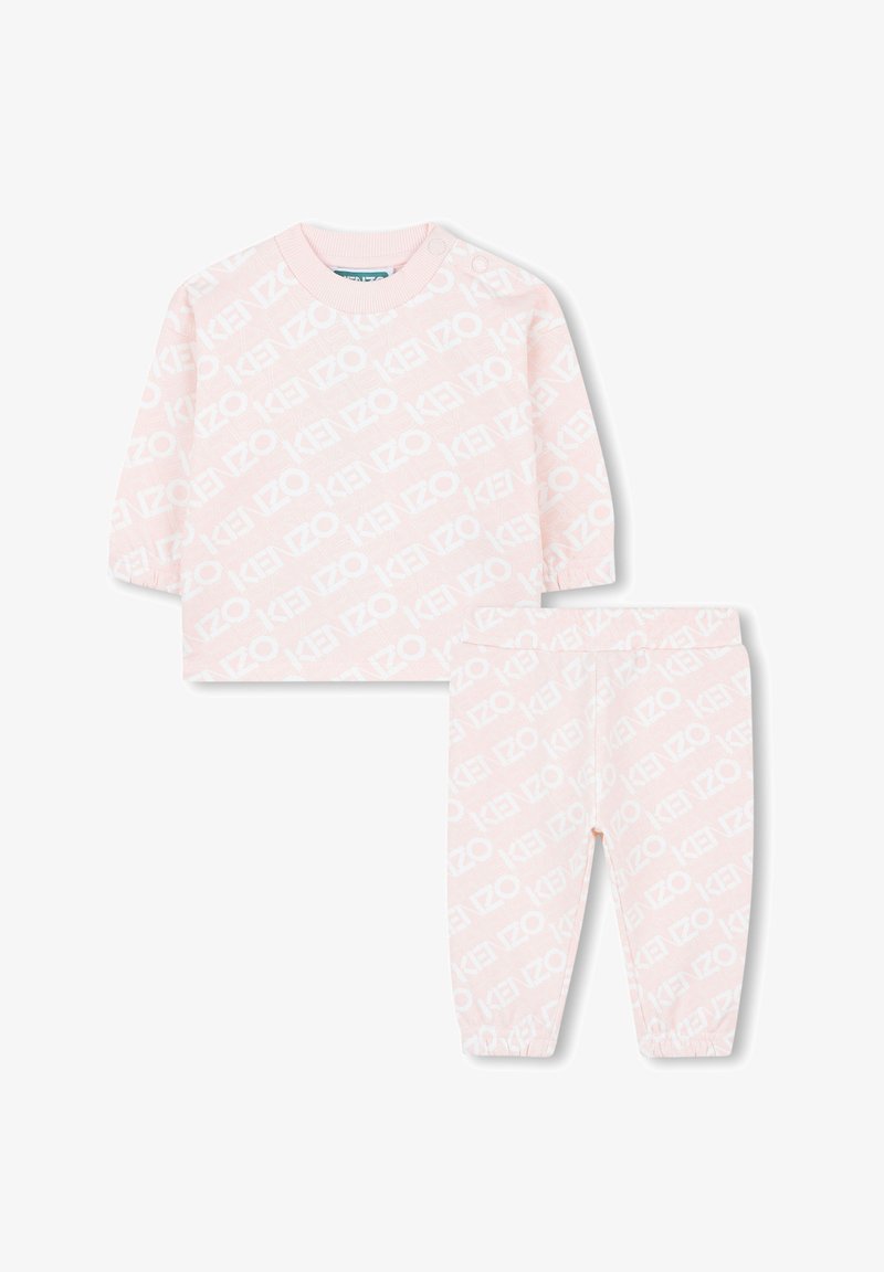 Roze katoenen tweedelige set met een lange mouw top en bijpassende broek, beide bedrukt met een wit logopatroon. Elastische manchetten aan de broek.