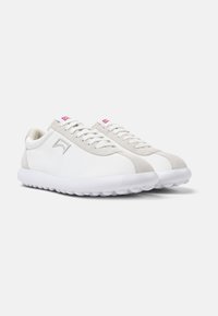 Scarpe da ginnastica bianche e grigie chiare con una superficie liscia, design a lacci, dettaglio del logo e suola in gomma strutturata.