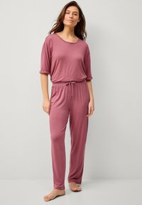 Lichtgewicht, ontspannen passende pyjama set in een gedempte rozenkleur. Korte mouwen top met opgerolde manchetten, broek met trekkoord in de taille, gladde stof, volledige lengte.