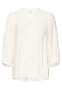 Blusa blanca con textura, escote en V, mangas abullonadas de tres cuartos y cierre de botones. Presenta un intrincado borde de encaje en la parte delantera.