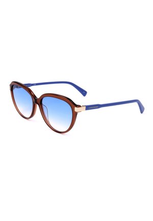 Occhiali da sole marroni a forma di occhio di gatto con lenti a gradiente blu e aste blu con il marchio Longchamp su sfondo bianco.