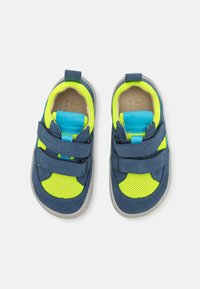 Chaussures pour enfants bleu et vert néon avec une tige en mesh et des accents en daim, comprenant deux bandes Velcro réglables et une semelle en caoutchouc.