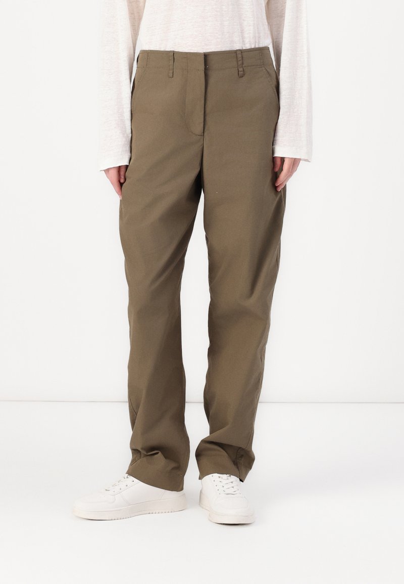 Khaki straight-leg trousers made of cotton twill, featuring a zip fly, belt loops, and side pockets, paired with white sneakers.