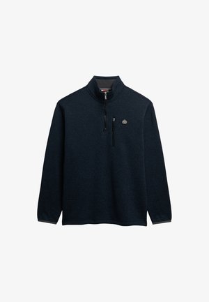 Granatowy polarowy pulower z ćwierć zamkiem, wysokim kołnierzem i zamkniętą kieszenią na piersi. Gładka tekstura z delikatnym melanżowym wzorem i detalem z logo.
