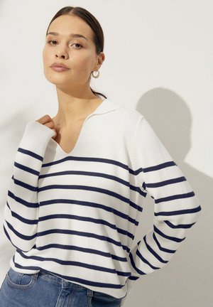 Gestreepte pullovertrui in wit en marineblauw, met een V-hals, lange mouwen en een zachte textuur. Casual ontwerp met zichtbare stikdetails.